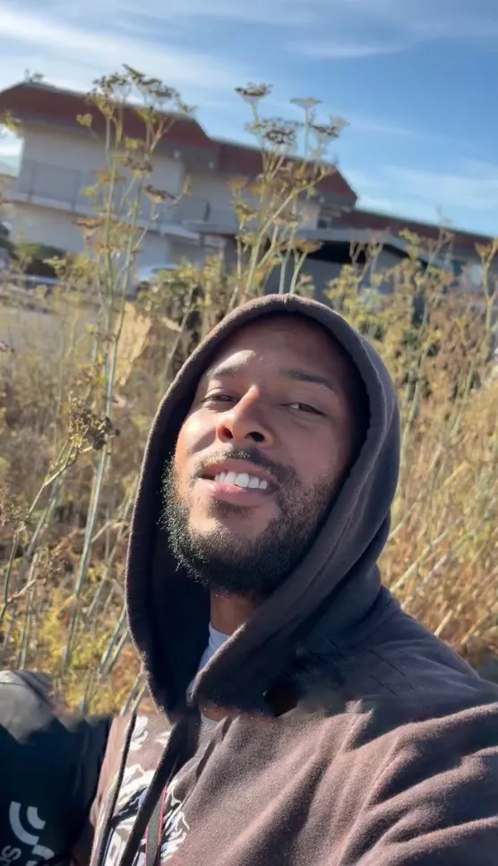 Chantz Mula smiling in a hoodie outdoors during his walk.