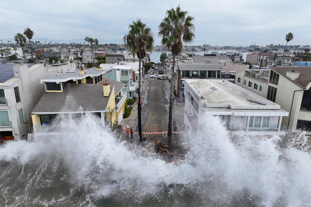 Large waves crash against a walkway in front of homes in Long Beach, Calif., as Tropical Storm Rachel approaches.