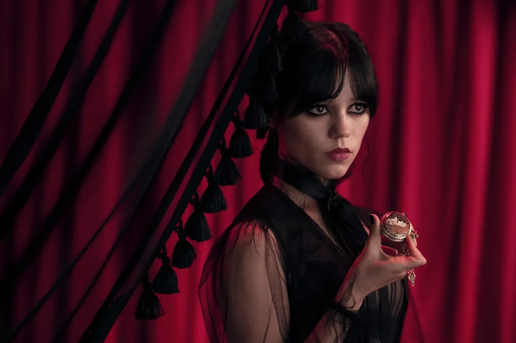 Jenna Ortega as Wednesday Addams holding a pocket watch.