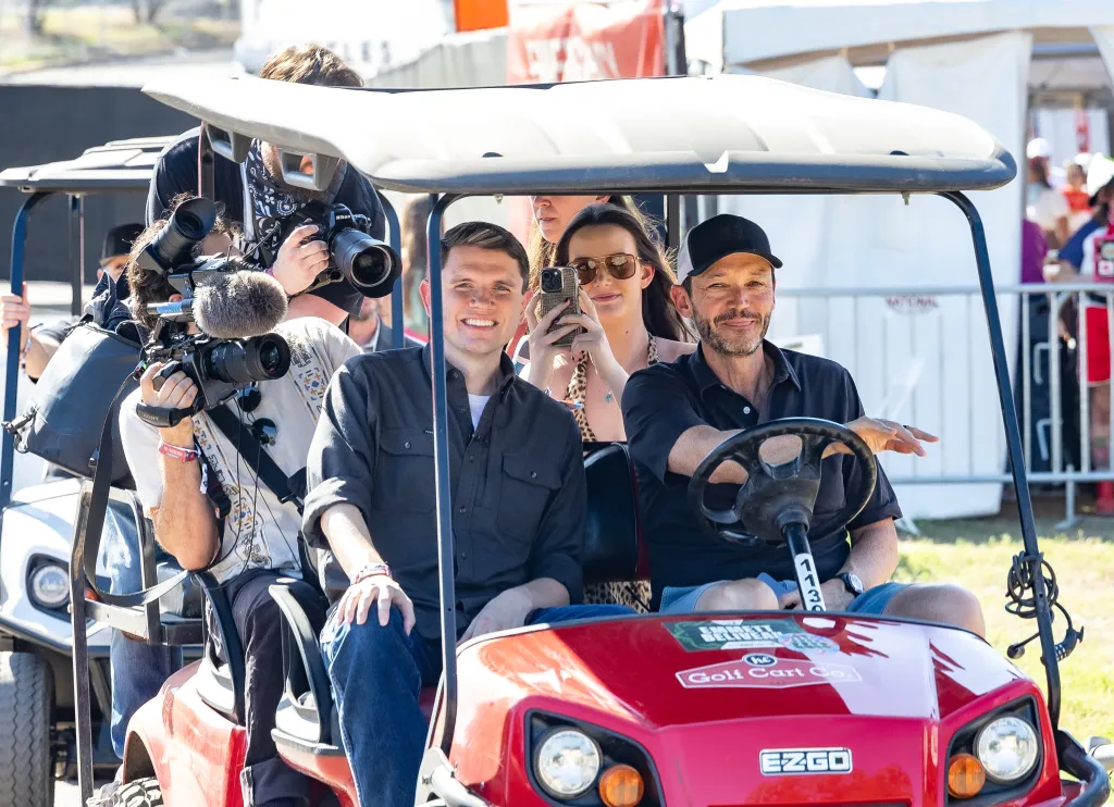 Politician James Talarico sits in a golf cart with others at the Austin City Limits Music Festival.