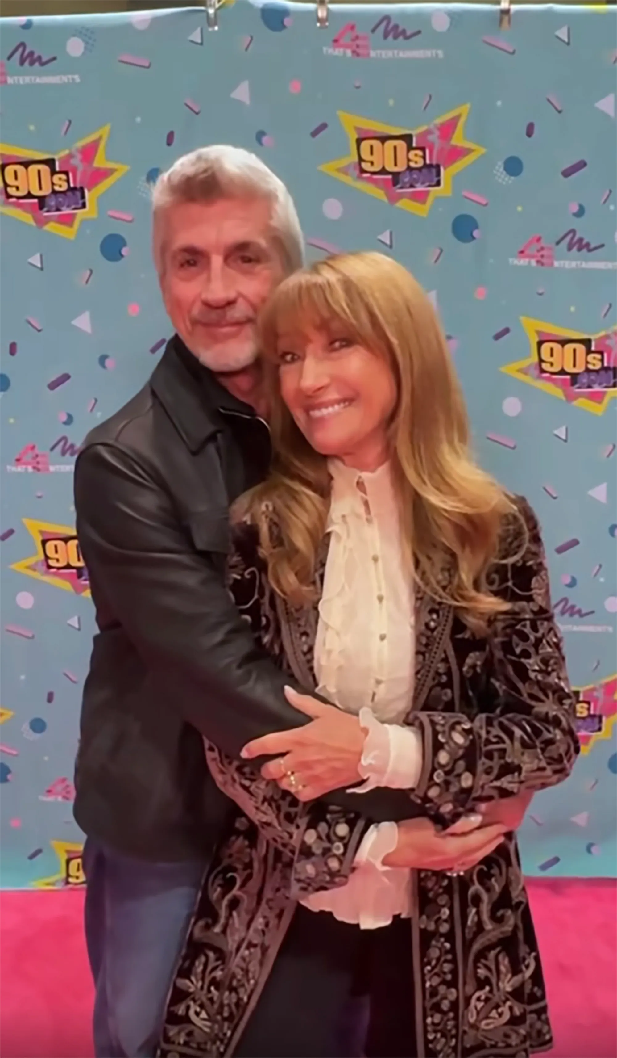 Jane Seymour and Joe Lando posing together in front of a 90s Con backdrop.
