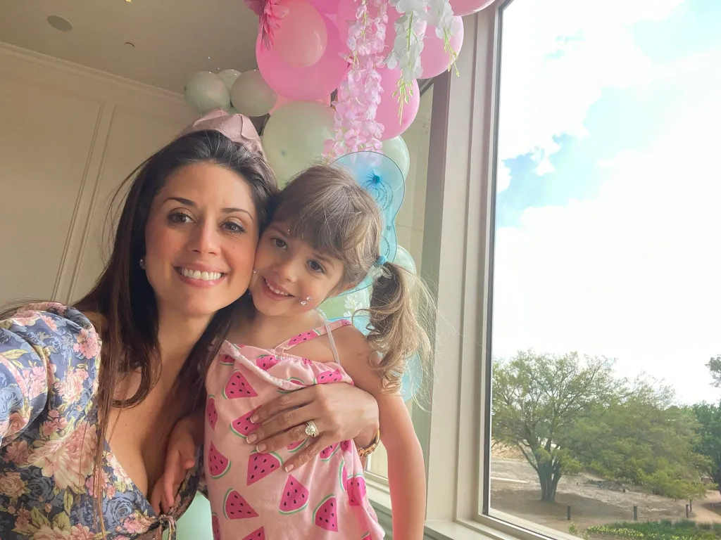 Cibelle Savella and her daughter Vivian Savella smiling together indoors.
