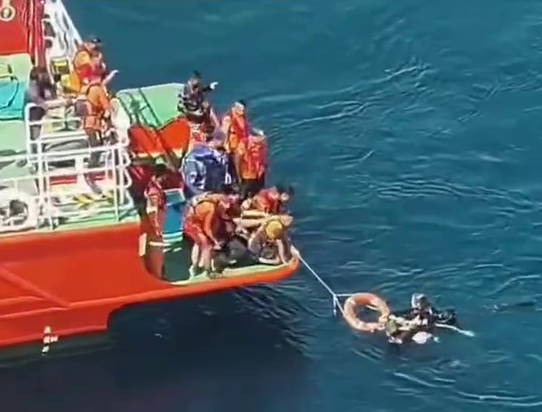 Tourists being rescued by a boat in Indonesia.
