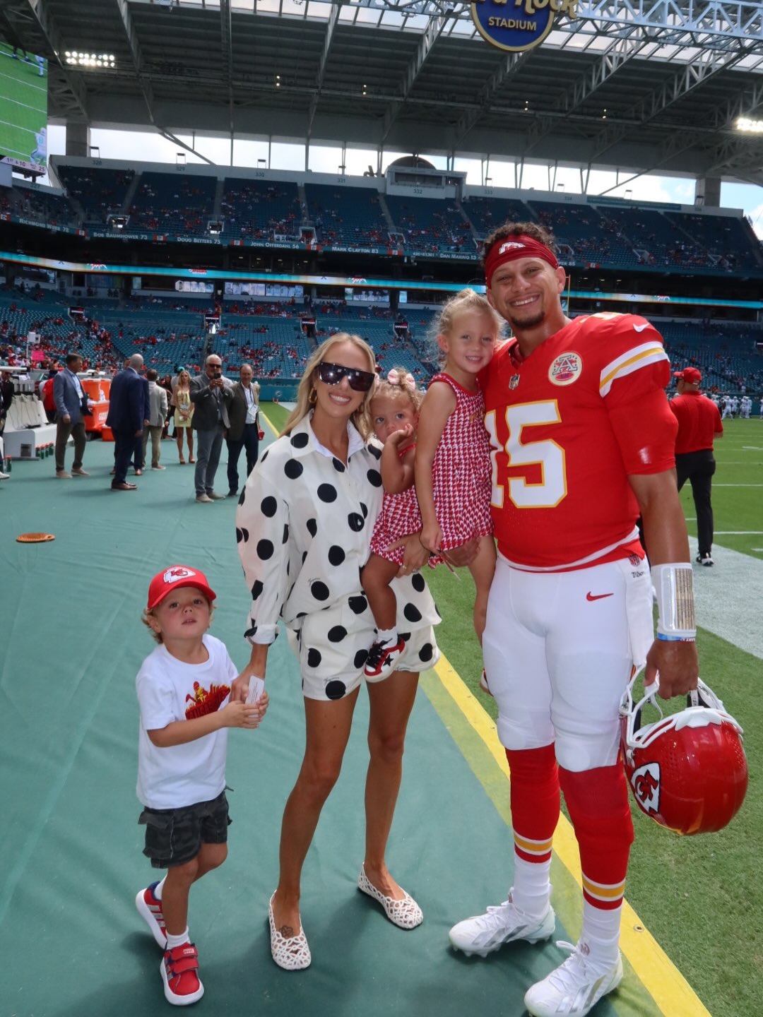 Patrick Mahomes and Brittany Matthews pose on the field with their three children at Hard Rock Stadium.