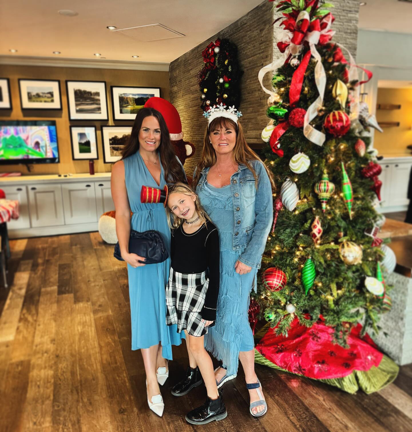 Jeana Keough with her daughter Kara Bosworth and granddaughter standing in front of a Christmas tree.