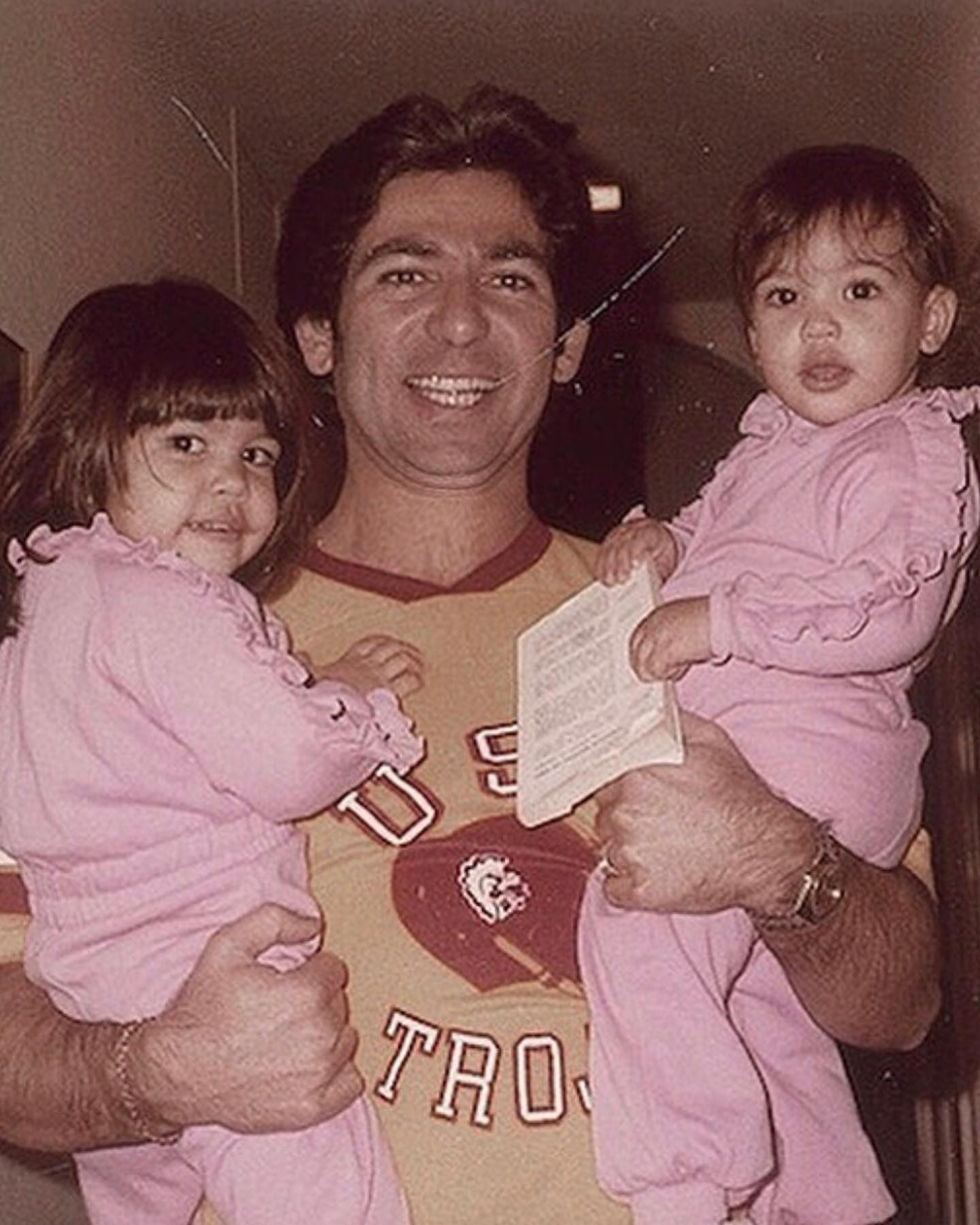 Robert Kardashian Sr. holding young Kourtney and Kim Kardashian.