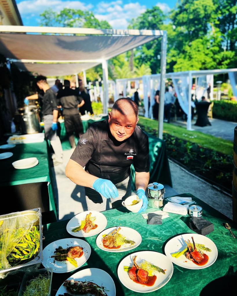 Chef plating gourmet meat dishes outdoors at a catering event.