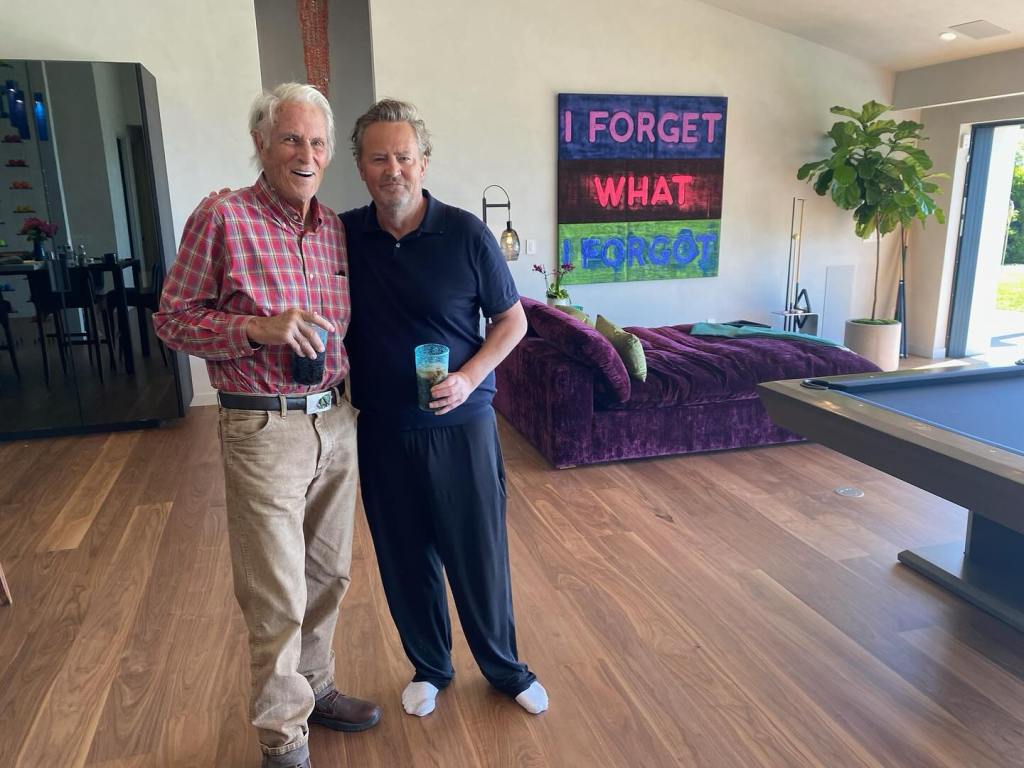 Matthew Perry and his father John standing together inside a room.