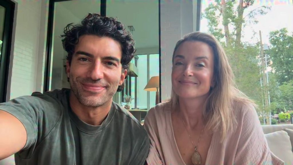 Justin Baldoni and a woman smiling for a selfie together indoors.