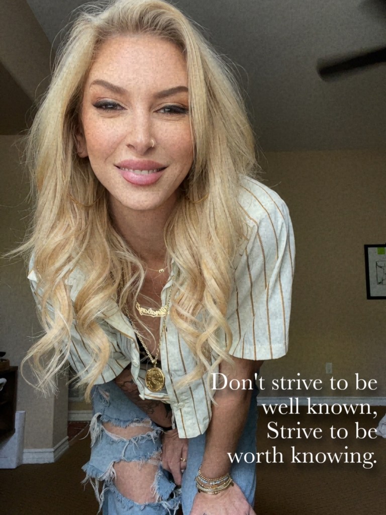 Lindsay Brooke smiles warmly while leaning forward, wearing a striped shirt and ripped jeans, with the text 