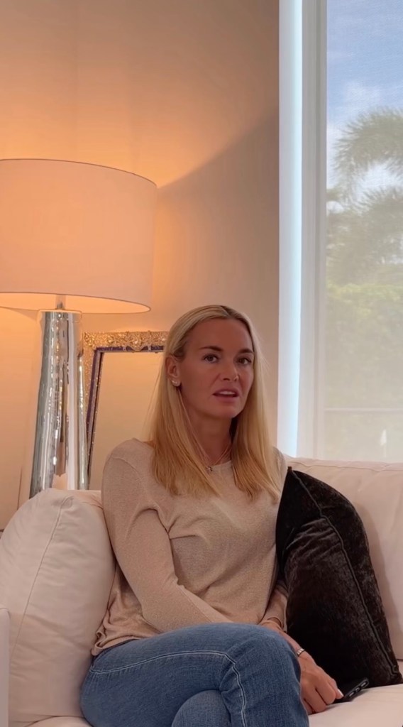 Vanessa Trump seated on a white sofa indoors, with a lamp and a window in the background.