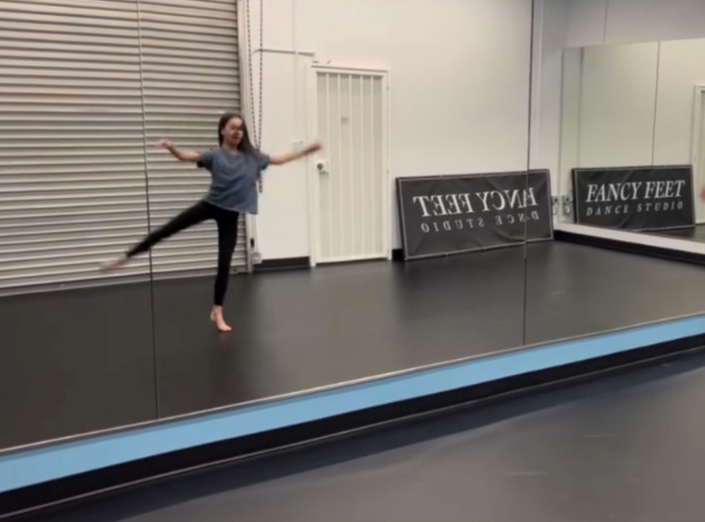 Fiona Lowe dances in a dance studio with a banner that reads 