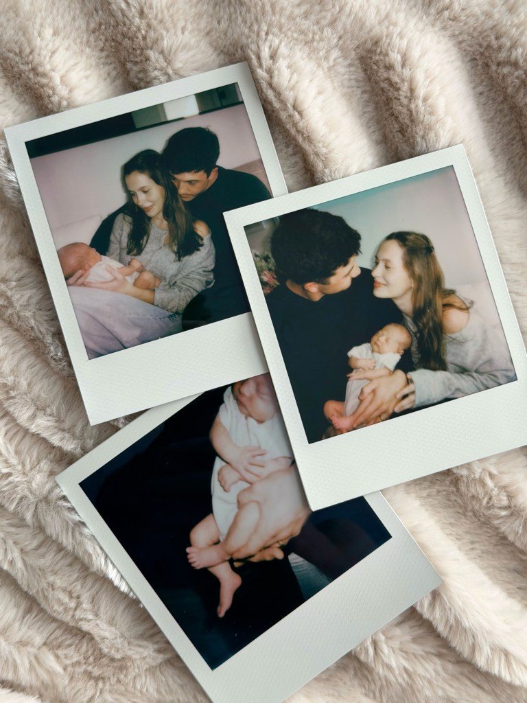 Collage of three Polaroid photos of a young couple holding their newborn baby, scattered on a fluffy blanket.