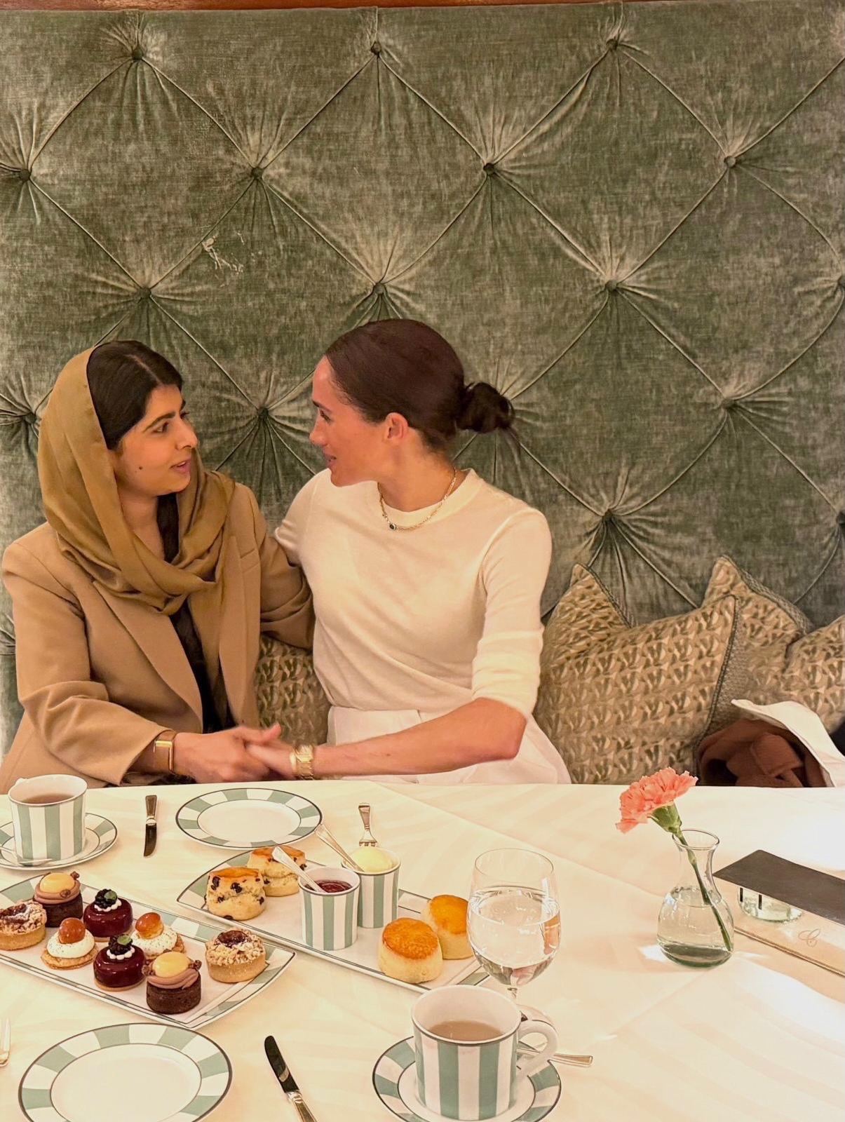Meghan Markle and Malala Yousafzai sitting together at a table during their secret London meet-up.