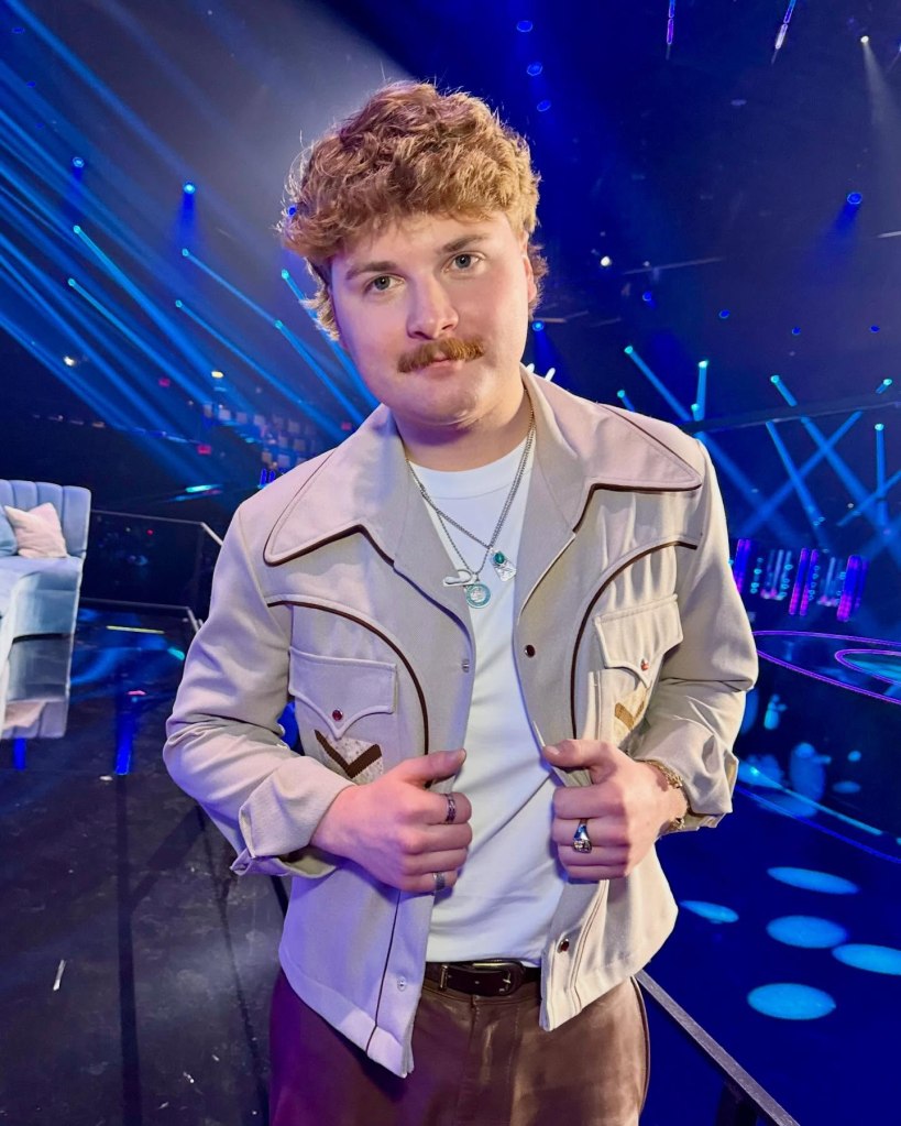 Brooks Rosser standing in a brightly lit studio wearing a light-colored jacket.