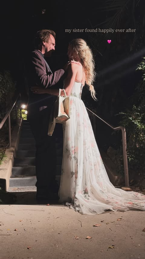 Jason Segel and Kayla Radomski embracing on stairs at night.
