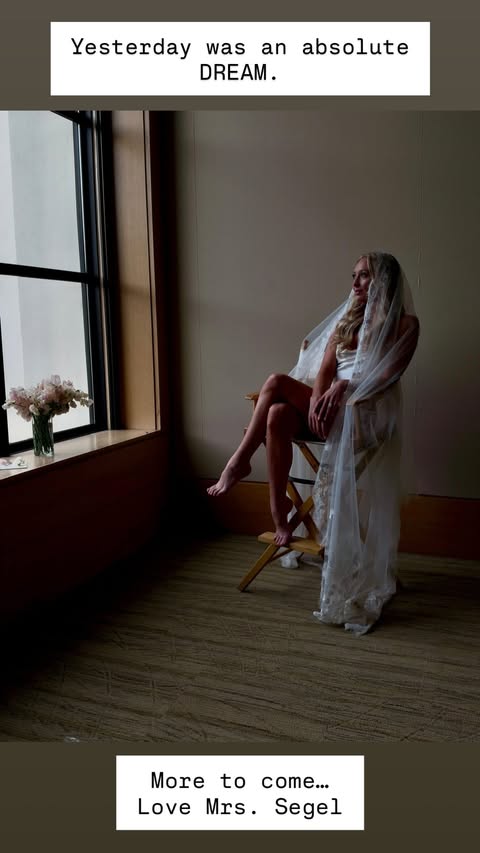 Kayla Radomski in a bridal veil sitting in a chair near a window.
