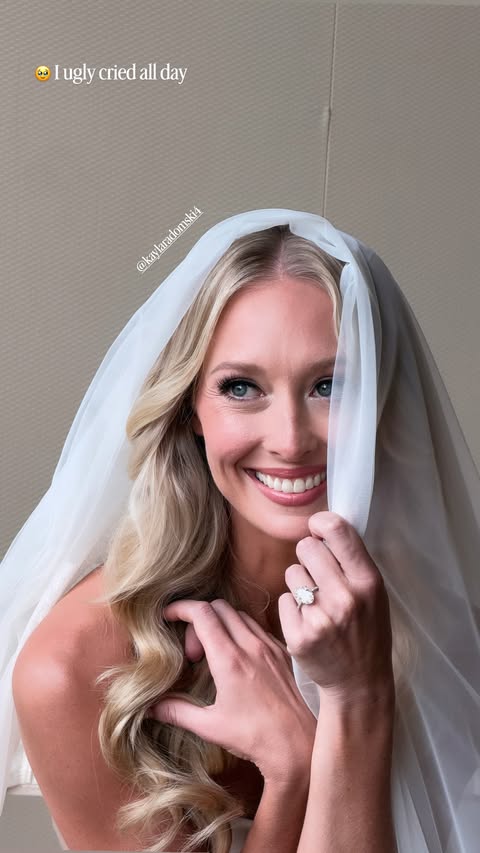 Kayla Radomski smiling in a bridal veil and engagement ring.