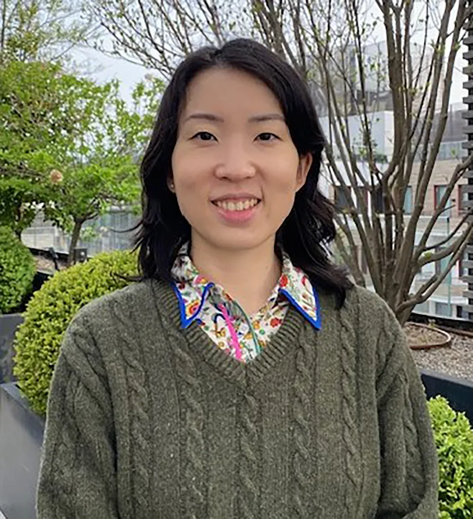 Dr. Wei Qi A young Asian woman with brown hair in a green sweater