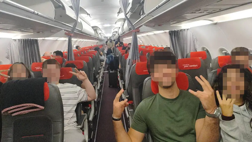 Passengers sit onboard an Austrian Airlines flight after it landed following a reported bomb threat.