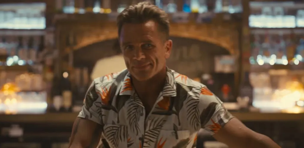 David Hasselhoff in the Baywatch trailer, wearing a tropical shirt inside a bar.