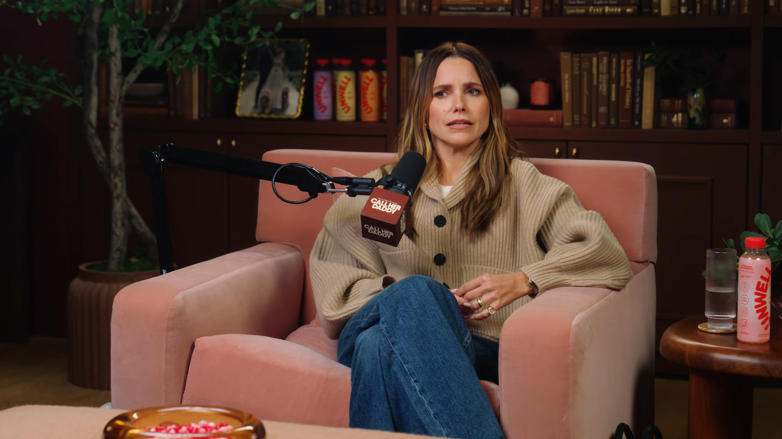 Sophia Bush sitting on a pink armchair during an interview on the Call Her Daddy podcast.