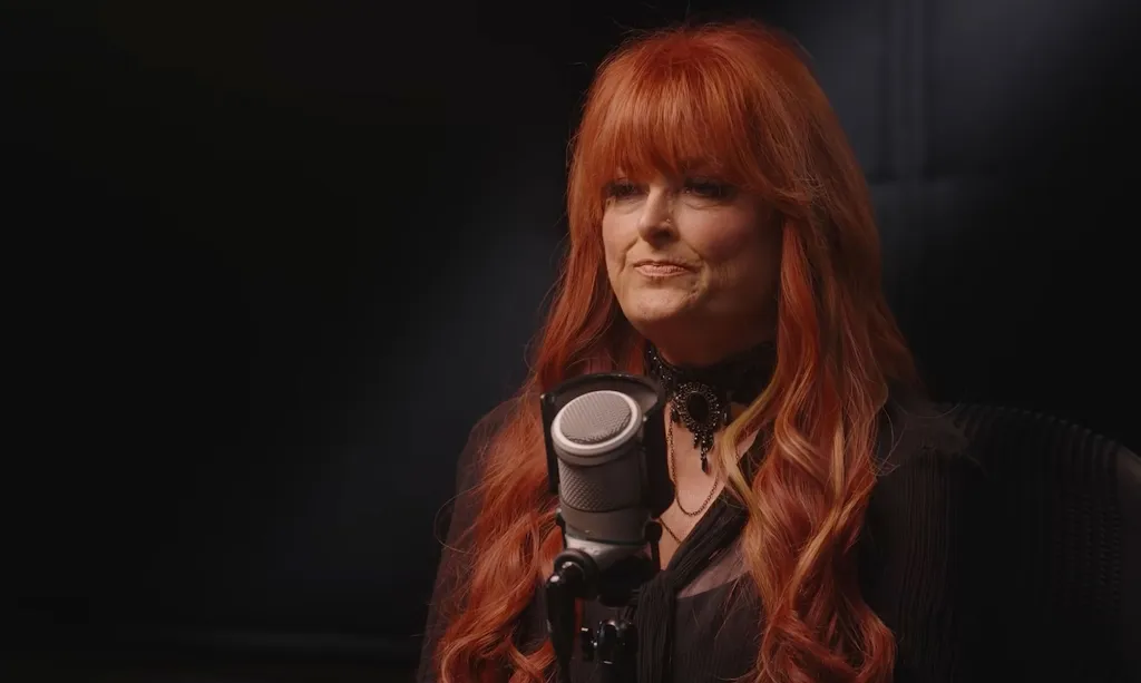 Wynonna Judd speaking into a microphone.