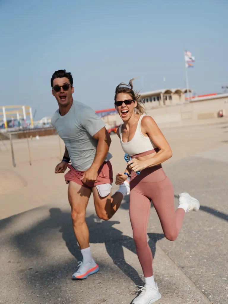 Tyler Cameron and fiancée Tate Madden running outdoors.